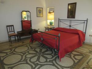 レウカにあるVilla Superior Vista mareのベッドルーム1室(赤いベッド1台、椅子、鏡付)
