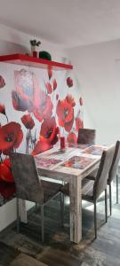 a dining room table with chairs and a painting of red flowers at Ferienwohnung Nr 12 inkl Bettwäsche Handtücher Endreinigung in Goslar