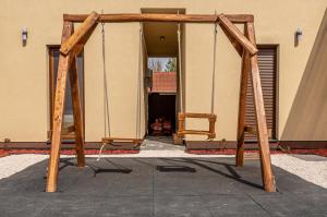 a swing set in front of a building at H&H Apartments Poroszló in Poroszló