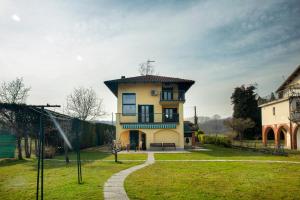 a large yellow house with a roof on top of it at Ypa Home Lago di Candia Canavese in Candia Canavese