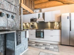 eine Küche mit weißen Schränken und einem Kühlschrank in der Unterkunft Holiday Home Juurakkopirtti by Interhome in Keuruu