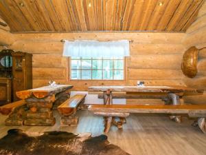 Cabaña de madera con mesas y ventana en Holiday Home Juurakkopirtti by Interhome, en Keuruu