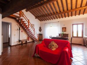 een woonkamer met een rode bank en een trap bij Apartment Le Palaie - 'Piscina' - PEC205 by Interhome in Molino Mazzetti