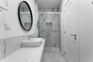 bagno bianco con lavandino e specchio di Home Out Rooms & Apartments a Lisbona