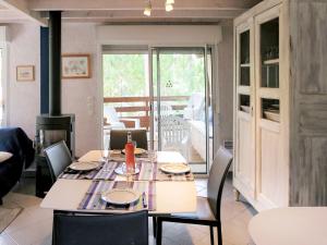 a dining room with a table and chairs and a fireplace at Chalet La Cigale - MAU190 by Interhome in Carcans