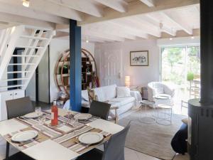 a dining room and living room with a table and chairs at Chalet La Cigale - MAU190 by Interhome in Carcans