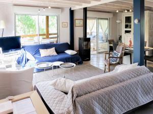 a living room with a blue couch and a table at Chalet La Cigale - MAU190 by Interhome in Carcans