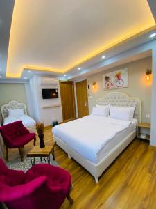um quarto com uma grande cama branca e 2 cadeiras em PALMERA OLD CITY em Istambul
