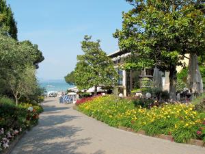 ścieżka ogrodowa z kwiatami przed budynkiem w obiekcie Holiday Home Bella Italia-5 by Interhome w mieście Peschiera del Garda