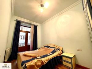 a small bedroom with a bed and a window at Armenak Apartment Near To Republic Square in Yerevan