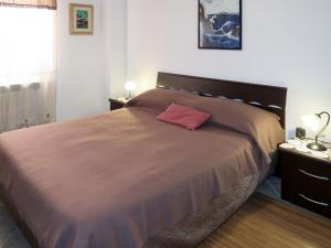 Un dormitorio con una cama grande con una almohada roja. en Apartment Samuele by Interhome, en Civezza