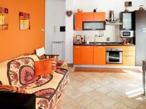 un soggiorno con divano e una cucina con armadietti arancioni di Apartment Samuele by Interhome a Civezza