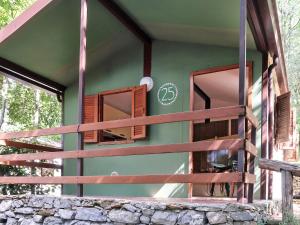 a green house with windows and a fence at Holiday Home Bungalow B - AEG401 by Interhome in Villanova dʼAlbenga