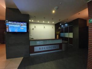 a reception desk in a building with a tv on the wall at LIDO Apartamenty in Sarbinowo