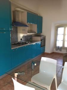 a blue kitchen with blue cabinets and white chairs at HH Hermoso Housing VALENZA in Valenza +127 photos