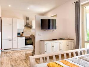 eine Küche mit weißen Schränken und einem TV an der Wand in der Unterkunft Apartment Stella - Villa di Sogno by Interhome in Capoliveri