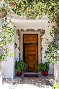 a wooden door on a building with two potted plants at Pergola Boutique Hotel in Cascais