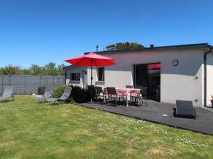 eine Terrasse mit einem Tisch, Stühlen und einem Sonnenschirm in der Unterkunft Holiday Home Ty Amiets - CED245 by Interhome in Cléder