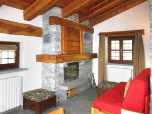 a living room with a stone fireplace at Chalet Casot Pra Viei - SMY100 by Interhome in Sampeire