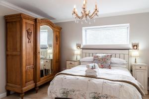 a bedroom with a large bed and a chandelier at Nerf-af ROOMS at Onrus , Hermanus in Hermanus