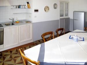 uma cozinha com uma mesa e cadeiras e um frigorífico em Apartment Ginevra - FLG209 by Interhome em Finale Ligure