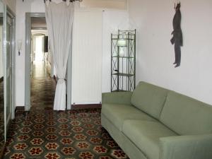 a living room with a green couch and a hallway at Apartment Ginevra - FLG209 by Interhome in Finale Ligure