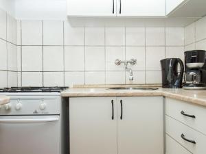 バラトンフェニヴェシュにあるHoliday Home Gerle by Interhomeの白いキャビネットとシンク付きのキッチン