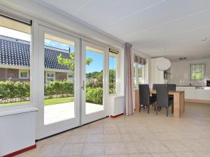 a dining room with a table and chairs and windows at Holiday Home in Noordwijk with Sunny Garden in Noordwijk aan Zee