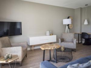 a living room with a couch and a tv at Apartment in tasteful farmhouse in De Cocksdorp in De Cocksdorp