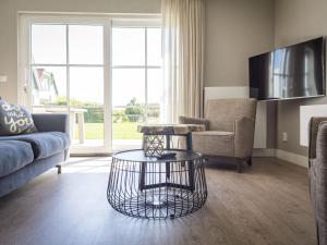 a living room with a couch and a table at Apartment in tasteful farmhouse in De Cocksdorp in De Cocksdorp