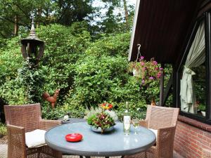 een blauwe tafel met bloemen op een patio bij Spacious Holiday Home in Eersel with Open Fire in Eersel
