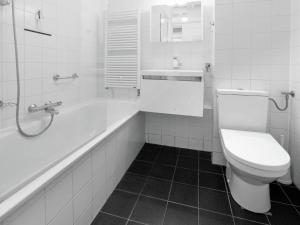 a bathroom with a toilet and a tub and a sink at Beautiful Holiday Home in Texel near Sea in Westermient