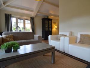 a living room with a couch and a table at Holiday home in the Veluwe in nature in Putten