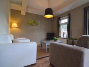 a living room with a couch and a table at Holiday home in the Veluwe in nature in Putten