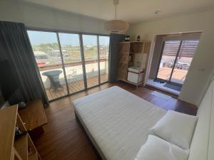 1 dormitorio con cama y ventana grande en Sigang Vacation Homestay en Xigang