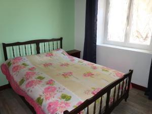 Una cama con colcha con flores rosas. en Holiday Home Les Confoulines by Interhome, en Usclades