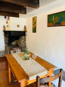 una mesa de madera con copas de vino y una chimenea en Tenuta Blancamar Country Bed & Breakfast, en Crisionis