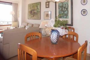 a living room with a table and chairs and a couch at Apartamento en primera linea para 4 personas in Port de Pollensa