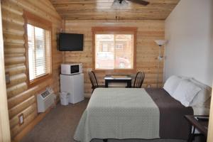 a bedroom with a bed in a wooden cabin at Bryce Country Cabins in Tropic