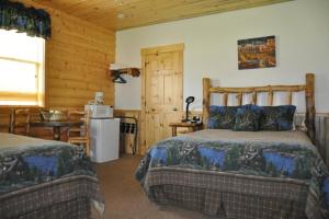 sypialnia z 2 łóżkami, kuchnia i stół w obiekcie Bryce Country Cabins w mieście Tropic