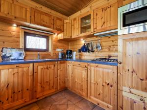 una cucina con armadi in legno e forno a microonde di Finnish house with enclosed garden near the Salland Ridge a Holten