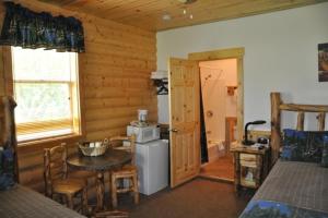 a room with a kitchen with a table and a refrigerator at Bryce Country Cabins in Tropic +21 photos