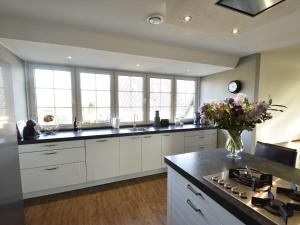 una cocina con armarios blancos y un jarrón de flores en Modern Holiday Home in Westerland with Sea Nearby, en Westerland