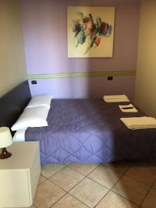 a bedroom with a bed and a purple wall at HH Hermoso Housing VALENZA in Valenza