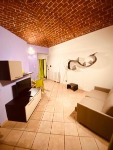 - un salon avec un canapé et une télévision dans l'établissement HH Hermoso Housing VALENZA, à Valenza