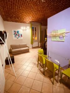a living room with a table and yellow chairs at HH Hermoso Housing VALENZA in Valenza