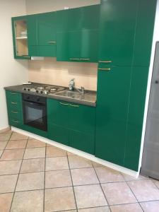 a green kitchen with a sink and a stove at HH Hermoso Housing VALENZA in Valenza