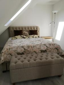 1 dormitorio con 1 cama con colcha de flores en Apartamentai Ramybė, en Nida
