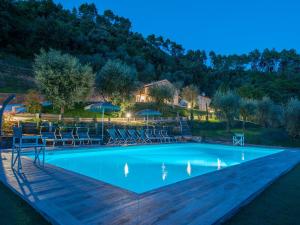 uma piscina à noite com cadeiras e guarda-sóis em Holiday Home Campodori by Interhome em San Martino in Freddana