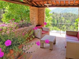 um pátio com uma mesa, cadeiras e flores em Holiday Home Campodori by Interhome em San Martino in Freddana